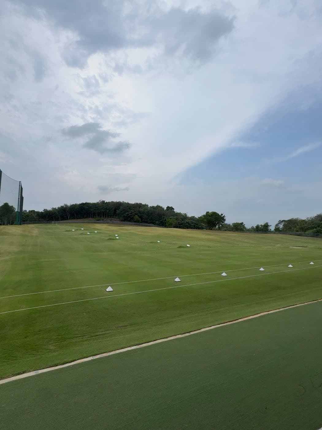 The natural grass driving range at Epsom College Malaysia, with target greens and practice stations