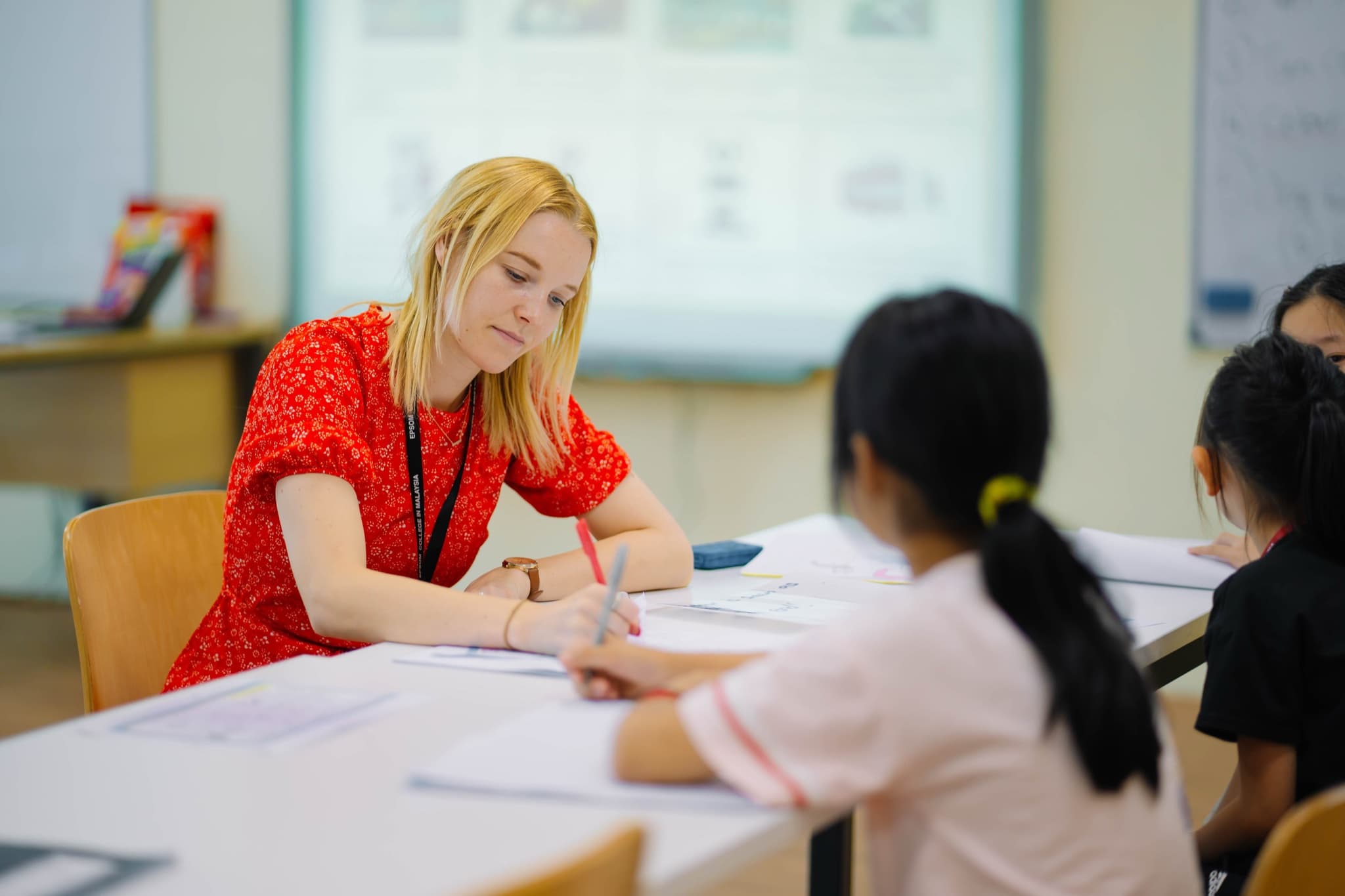 A teacher leading an English class with a small group of campers